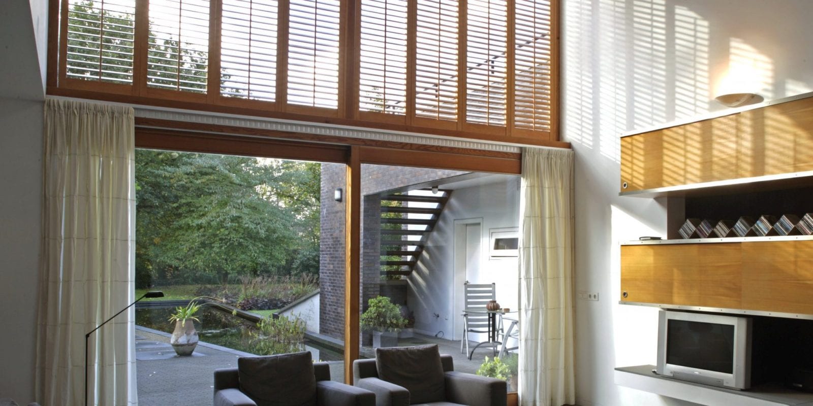 Balcony doors with tall shutters in a bright modern living room